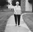 blind women walking outside her apartment with cane assistance