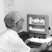 person viewing computer screen with large text